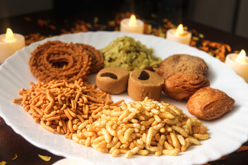 Plate With Crunchy Indian Snack. Holiday Time With Fresh and Tasty Food. Indian Festival of Lights. Candles and Petals Decorations