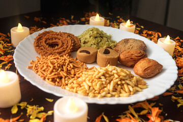 Plate Of Mix Indian Snack. Holiday Time With Fresh and Tasty Food. Indian Festival of Lights. Candles and Petals Decorations