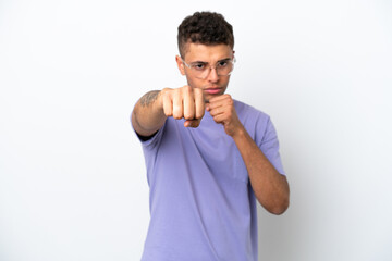 Young caucasian Brazilian man isolated on white background with fighting gesture