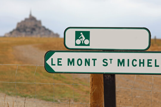 Sign And Arrow With The Inscription LE MONT ST MICHEL Of The Cycle Path That Goes To The Famous Abbey On The Island In France