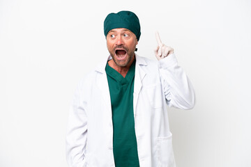 Middle age surgeon in green uniform isolated on white background intending to realizes the solution while lifting a finger up