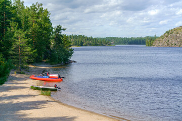 Rubber motor boats on the sandy shore of the lake.