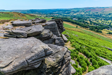 A view of rock strata and the Hope Valley from the top of the Bamford Edge, UK in summertime