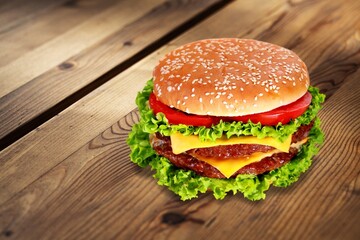 Tasty fresh cheese burger in wood background