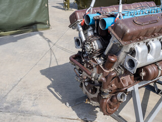 Engine close-up. Engine of truck or special equipment. Concept repair and maintenance of engines. Motor on metal stand. Motor is awaiting repair in open air. Automobile motor repair