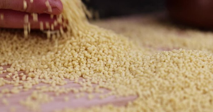 Move your hands cereal porridge couscous from wheat or millet, cooking dishes from traditional cereals crushed yellow couscous