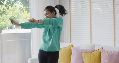 Gen Z girl shock in good news on social media app happy fun dance at home. Young sport fan asia people joy earn bonus loan money, awe face look at mobile phone, win online play bingo game or job hired