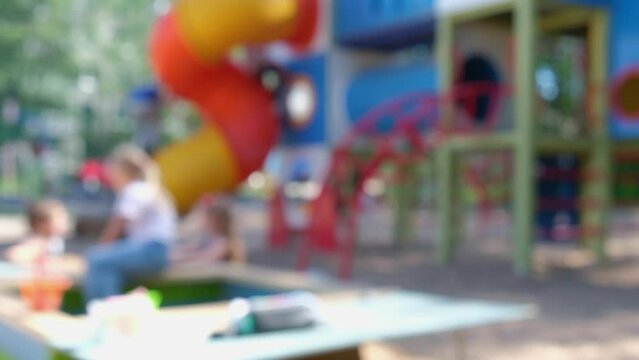 abstract background in blur, playground with children running and playing, play area without focus, sunny summer day