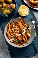 Sweet roasted carrots with sauce and green herbs, close up. Festive dish for celebration Thanksgiving Day. Top view, Flat-lay