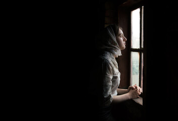 Fototapeta premium Woman praying at the window