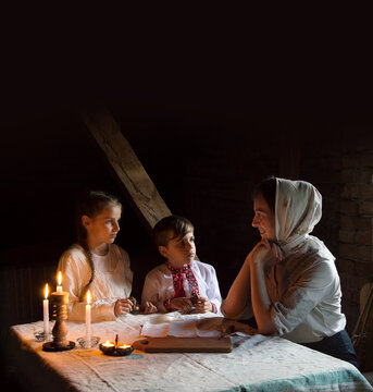 Poor Family At The Table. Mother Gave The Children The Last Piece Of Bread