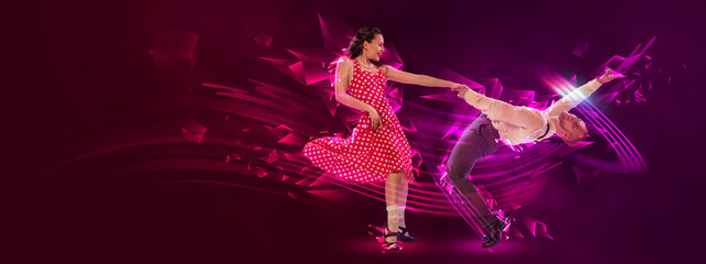 Excited man and woman, professional dancers dancing lindy hop over dark background with neon fluid elements. Art, beauty, dance concept