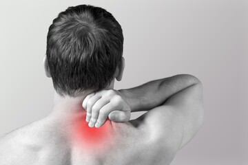 Man suffering from shoulder blade pain. Trigger point. Hand holding shoulder with red spot. Health care, medicine concept. - obrazy, fototapety, plakaty
