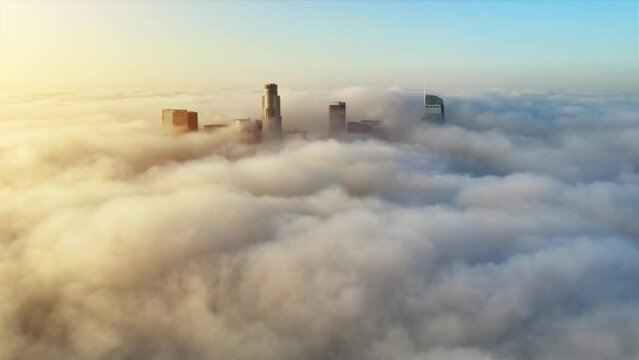 Aerial of the tall buildings of downtown Los Angeles poking through low clouds