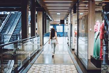 Modern Latina young woman walking in large modern mall. Young pretty brunette female consumer