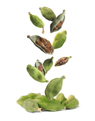 Dry green cardamom pods with seeds falling on white background