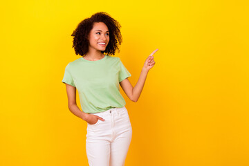 Photo of lovely brunette curly lady look promo wear t-shirt pants isolated on bright yellow color background