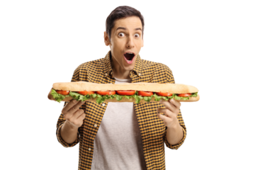 Young man eating a tasty long sandwich in a baguette