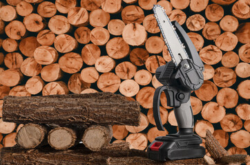 Light chain saw with battery on a pile of sawn tree trunks in the garden.