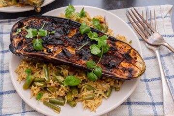 Aubergine caramelised under the grill with spices, garnished with coriander, and served on spicy rice and beans. 