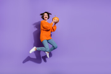 Fototapeta na wymiar Full length body size view of lovely cheery funny girl jumping hold pumpkin having fun isolated on bright purple violet color background