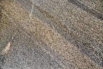 Gray granite background with a beautiful pattern of diagonal stripes on a clear sunny day, texture backgrounds for graphic design. Abstract wallpaper.