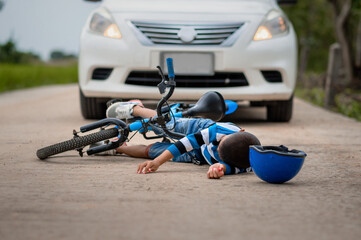 A boy was injured because his bicycle collided with a car on the road. Asian boy was hit by car. The concept of road accidents and reduction of accidents from use of cars on the road. selective focus.