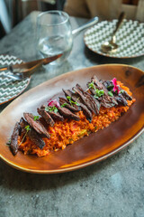 Vista superior churrasco angus sobre arroz amarillo con verduras, toques de plátano maduro y aguacate. Concepto de comida de alto nivel