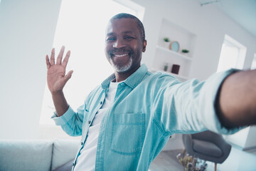 Portrait of positive aged man make selfie vlogging greeting his blog followers in modern house apartment