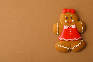 Christmas human shaped gingerbread cookie on brown background, top view. Space for text
