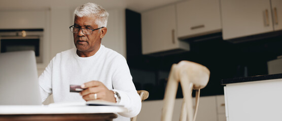 Senior man using a credit card to do some online shopping