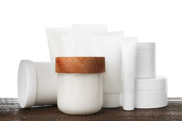 Set of different creams on wooden table against white background