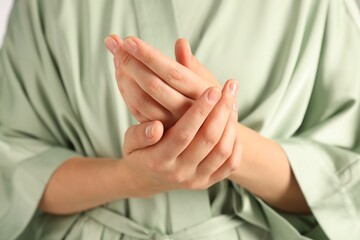 Woman applying luxury cosmetic cream onto hand, closeup