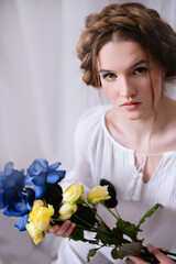 Ukrainian girl with blue yellow flowers in white