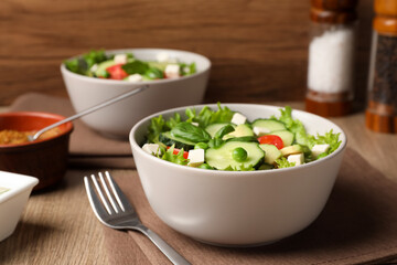 Tasty fresh salad with cucumber served on wooden table
