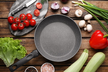 Flat lay composition with frying pan and fresh products on wooden table