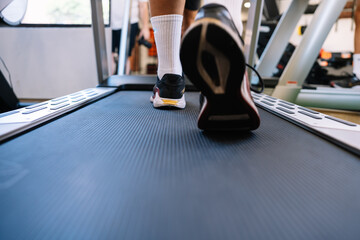 Fototapeta na wymiar Crop sportsman walking on treadmill