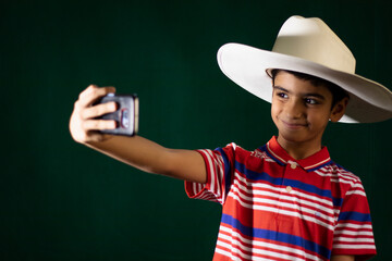 A young boy taking selfie in white cowboy hat