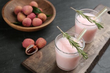 Delicious lychee cocktails with rosemary and fresh fruits on black table