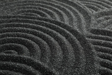Naklejka premium Black sand with beautiful pattern, closeup. Zen concept
