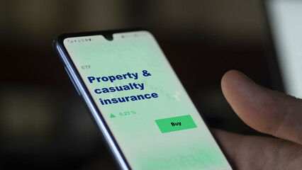Property and casualty insurance an investor's analyzing the insurance coverage fund on screen. A phone shows the ETF's prices property & casualty insurance