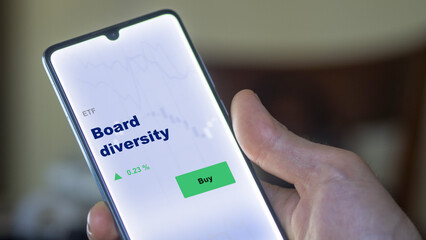 An investor's analyzing the board diversity etf fund on screen. A phone shows the ETF's prices stocks to invest