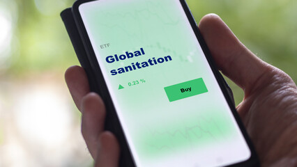 An investor's analyzing the global sanitation etf fund on screen. A phone shows the health care ETF's prices stocks to invest