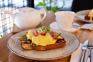 Breakfast sandwich with toasted bread, ham, scrambled mushrooms, egg.