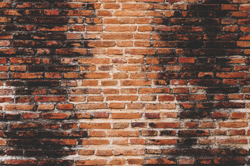 Red brick wall texture. Abstract brick wall background, wall of old, cracked bricks, with a weathered and faded surface.	