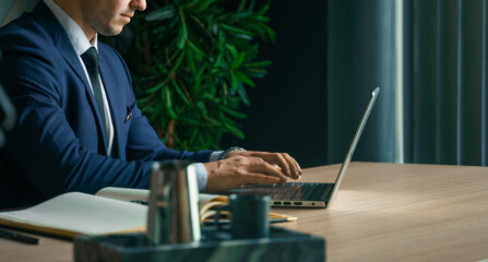 Businessman working with laptop in modern office. General manager,ceo. Young handsome confident man in suit sitting at table. Executive business leader. Entrepreneur career.Accountant bank workplace