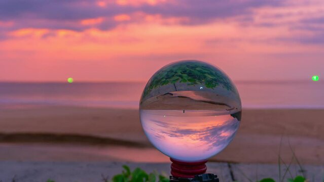 timelapse sunset in crystal ball the image that appears in an upside-down looks strange..The natural view of the sea and sky in beautiful sunset are unconventional and beautiful inside crystal ball.