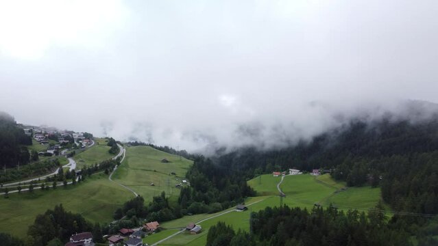 Aerial shot of the Reith bei Seefeld in Austria, with forest trees and houses on a cloudy day