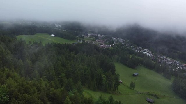 Aerial shot of the Reith bei Seefeld in Austria, with forest trees and houses on a cloudy day