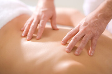 A Massage Therapist Practitioner treats a patients back injury with therapeutic massage.